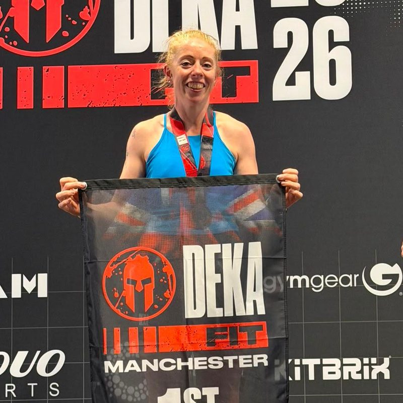 Vic smiling on the winner's podium at a fitness race in Manchester